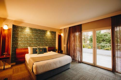 a hotel room with a bed and a large window at Double Bond Hotel Spa in Ankara