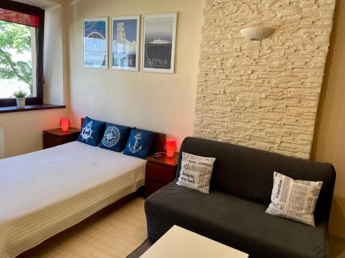 ein Schlafzimmer mit einem Bett und einer Couch in der Unterkunft City & Sea - Apartamenty i Mieszkania in Gdynia