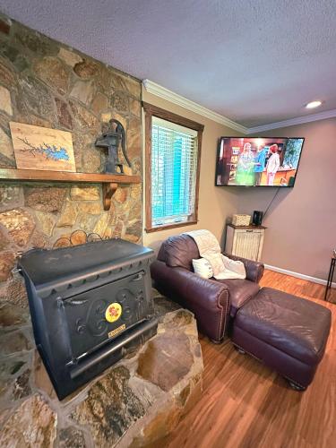 a living room with a stone wall with a stove at Lady of the Lake in Chapin