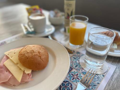 a table with a plate with a sandwich and glasses of water at Hotel Rural Cazorla Posada del Cordobés in Cazorla