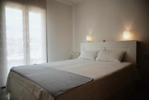 Villa Garbí by Alvent Holidays في كالونج: غرفة نوم بيضاء مع سرير كبير ونافذة