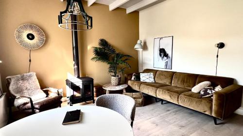 uma sala de estar com um sofá e uma mesa em Sfeervol vakantiehuisje 5 km van het strand em Oost-Souburg