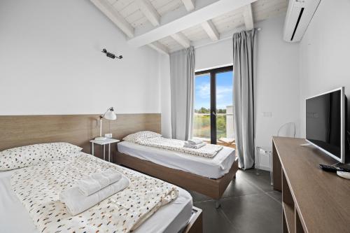 Una habitación de hotel con dos camas y un televisor. en Villa Kalu 1, en Krnica