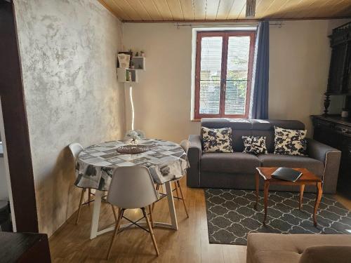 a living room with a table and a couch at Petit Paradis Croneuva in Strasbourg