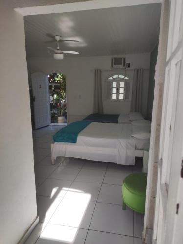 a bedroom with a bed and a green stool in it at LM Suítes in Búzios