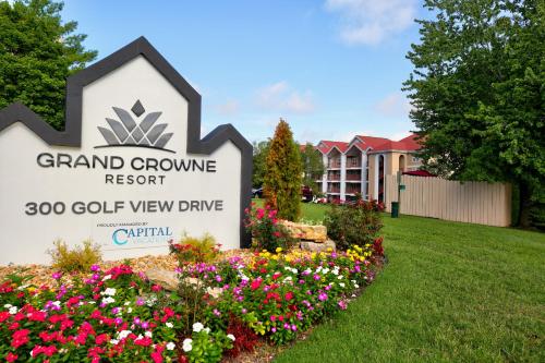 a sign for grand grove resort with flowers at Grand Crowne Resort by Capital Vacations in Branson