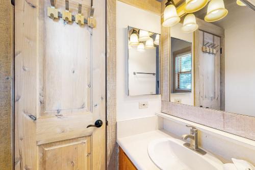 een badkamer met een wastafel, een spiegel en een deur bij Gold Bend Adventure in Truckee