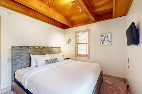 een slaapkamer met een groot wit bed en een televisie bij Gold Bend Adventure in Truckee
