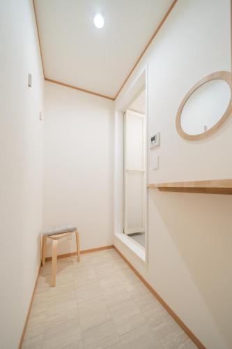 a room with a mirror and a bench and a window at Lawsoon in Uruma