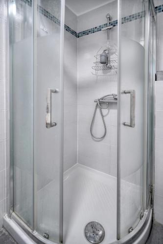 une douche avec une porte vitrée dans une salle de bain dans l'établissement Le Eve- 350M mer- 600 Palais-VCA, à Cannes