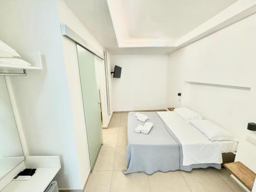 a white room with a bed and a window at La Gaetana in Gaeta