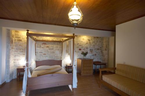 a bedroom with a canopy bed and a couch at Dream Hill Villas in Tavronitis