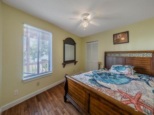 a bedroom with a bed and a ceiling fan at Just Another Day in Paradise in Surf City