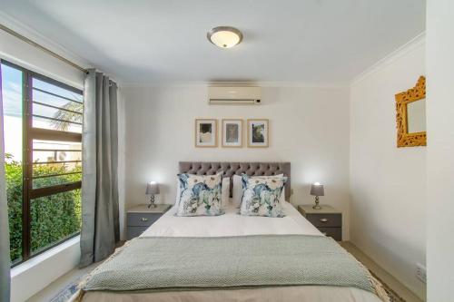 a bedroom with a large bed and a window at Chic, Cozy, Modern, Secure and Centrally Located in Cape Town