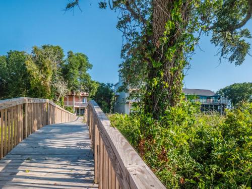 a wooden bridge with a tree on it at Just Another Day in Paradise in Surf City