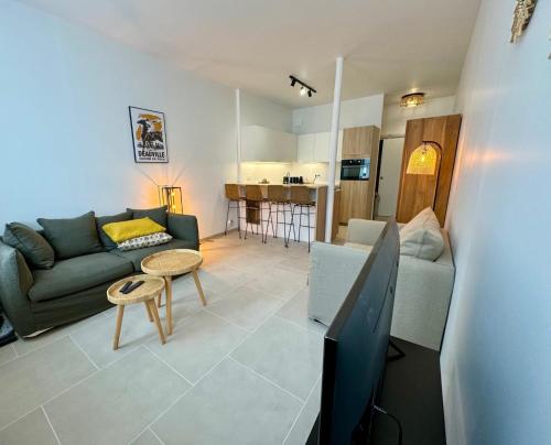 un salon avec un canapé et une télévision dans l'établissement Comfortable studio just steps from the sea, à Trouville-sur-Mer