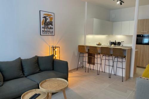 un salon avec un canapé et une cuisine dans l'établissement Comfortable studio just steps from the sea, à Trouville-sur-Mer