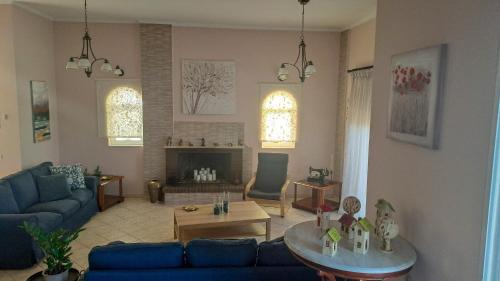 a living room with a blue couch and a table at Panorama View Aigio in Aígio