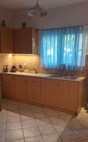 a kitchen with a sink and a blue curtain at Panorama View Aigio in Aígio