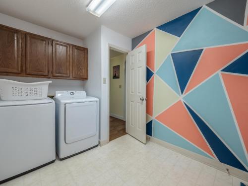 a kitchen with a washer and a geometric wall at Just Another Day in Paradise in Surf City