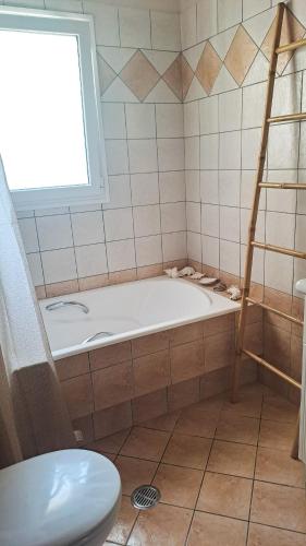 a bathroom with a bath tub and a window at Panorama View Aigio in Aígio