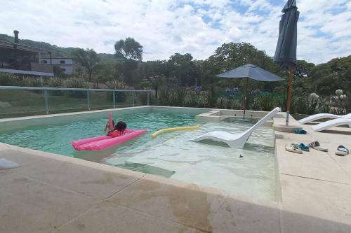 a child on a raft in a swimming pool at CASA VIVE, EL MEJOR PAISAJE De SALTA in Salta