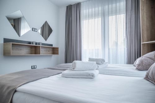 a white bedroom with two beds and a window at Japods Kingdom in Bihać