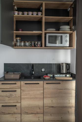 a kitchen with wooden cabinets and a microwave at Japods Kingdom in Bihać