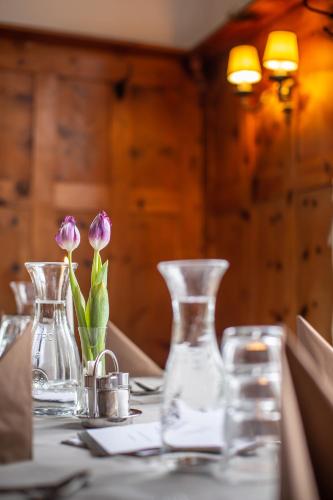 a table with two glass vases and flowers on it at Hotel Bergwirt Schönbrunn in Vienna