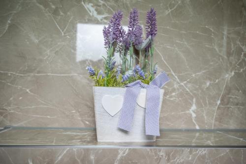 a vase filled with purple flowers on a shelf at Japods Kingdom in Bihać