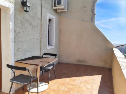 een tafel en stoelen in een kamer met een balkon bij Studio with sea view shared pool and furnished terrace at Badolato 1 km away from the beach in Badolato