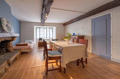 ein Esszimmer mit Tisch und Stühlen und einem Kamin in der Unterkunft Sarzeau centre - Le Cormoran in Sarzeau