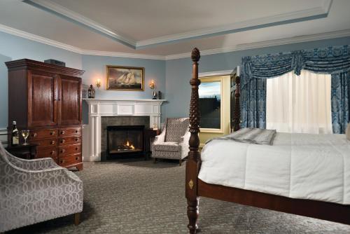a bedroom with a bed and a fireplace at Dan'l Webster Inn and Spa in Sandwich