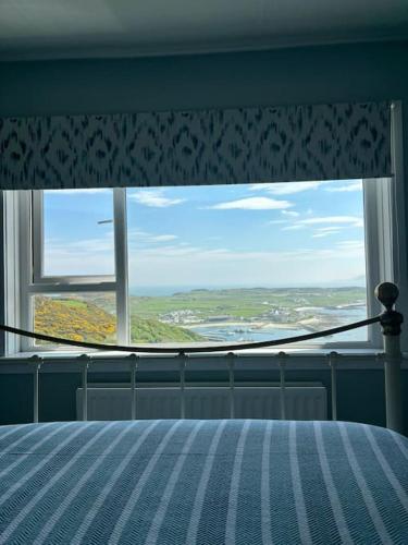 a bedroom with a bed and a window with a view at Stunning Rathlin cottage in Rathlin Island