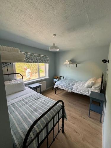 a bedroom with two beds and a window at Stunning Rathlin cottage in Rathlin Island