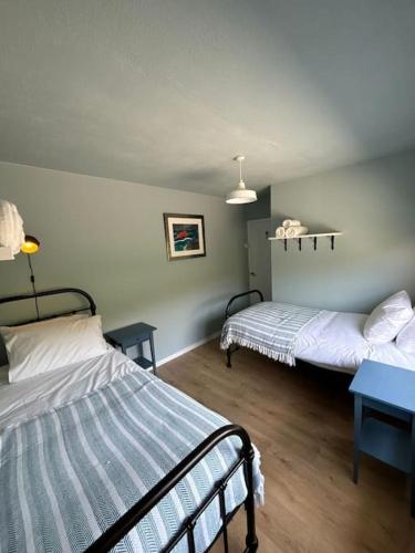 a room with two beds and a blue table at Stunning Rathlin cottage in Rathlin Island