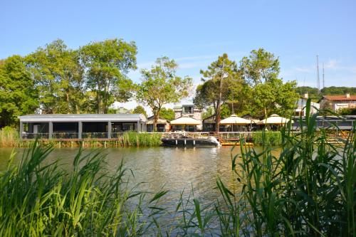 a boat in the water next to a building at Ağva Casa Rosa Bungalov Otel in Sile