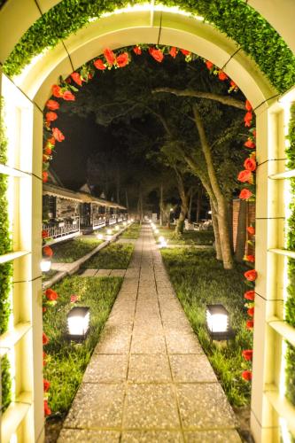 an archway with flowers and lights in a park at Ağva Casa Rosa Bungalov Otel in Sile