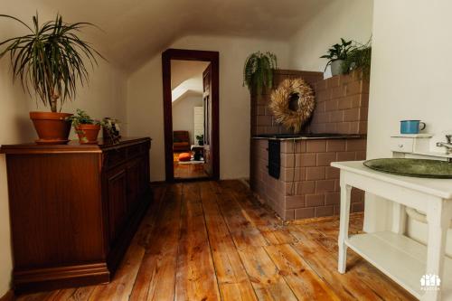 a room with a wooden floor and a hallway with plants at Puszcza - Przestrzeń Kreatywna in Andrzejów