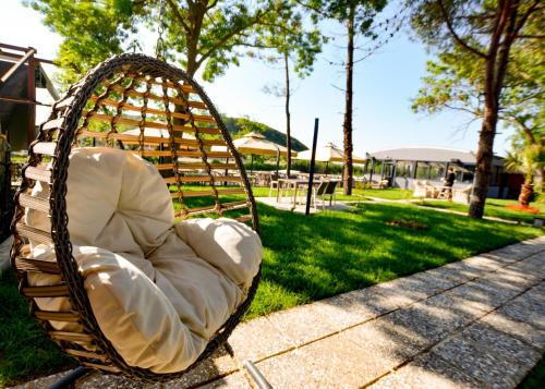 a wicker chair sitting on the grass in a park at Ağva Casa Rosa Bungalov Otel in Sile