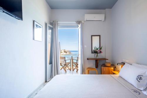 a bedroom with a bed and a view of the ocean at Akroyiali - Guesthouse in Gerolimenas