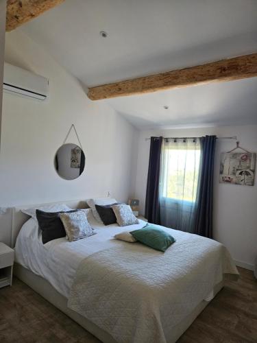 une chambre avec un lit avec des draps blancs et une fenêtre dans l'établissement Maison col de varra, à Porto-Vecchio