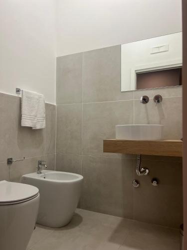 a bathroom with a white toilet and a sink at Ghe kalè Resort in San Paolo Bel Sito