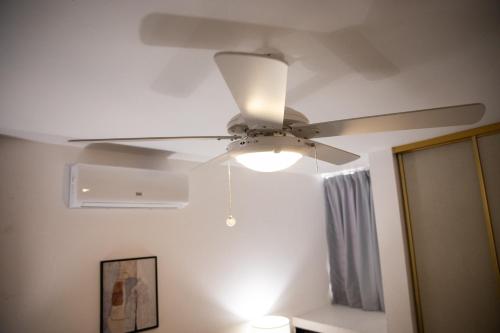 a ceiling fan in a room with a mirror at Residenciales H1 & H2 - Breakfast & Room Service - Airport close in Santiago de los Caballeros