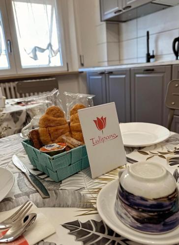a table with a basket of pastries and a sign on it at B&B Il Volturno in Falconara Marittima