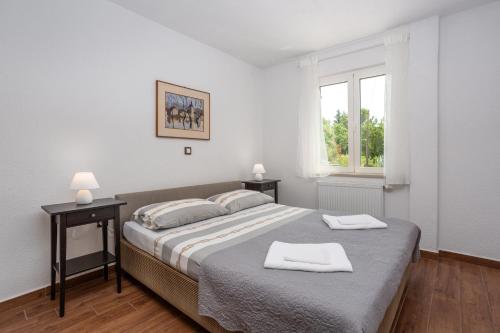sypialnia z łóżkiem i dwoma ręcznikami na nim w obiekcie Apartments Villa Temer w mieście Pinezići