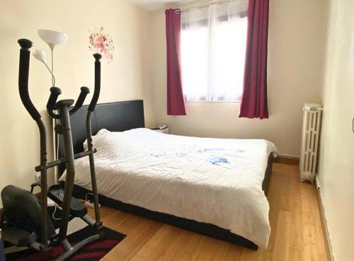 une chambre avec un lit, une chaise et une fenêtre dans l'établissement Appartement île-de-France, à Arcueil