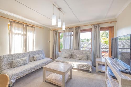 a living room with a couch and a tv at 1-on-Ross in Grahamstown