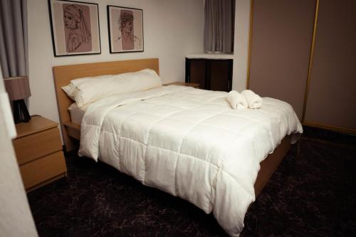 a hotel room with a bed with a white comforter at Residenciales H1 & H2 - Breakfast & Room Service - Airport close in Santiago de los Caballeros