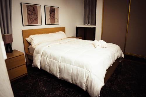 a hotel room with a bed with white sheets at Residenciales H1 & H2 - Breakfast & Room Service - Airport close in Santiago de los Caballeros